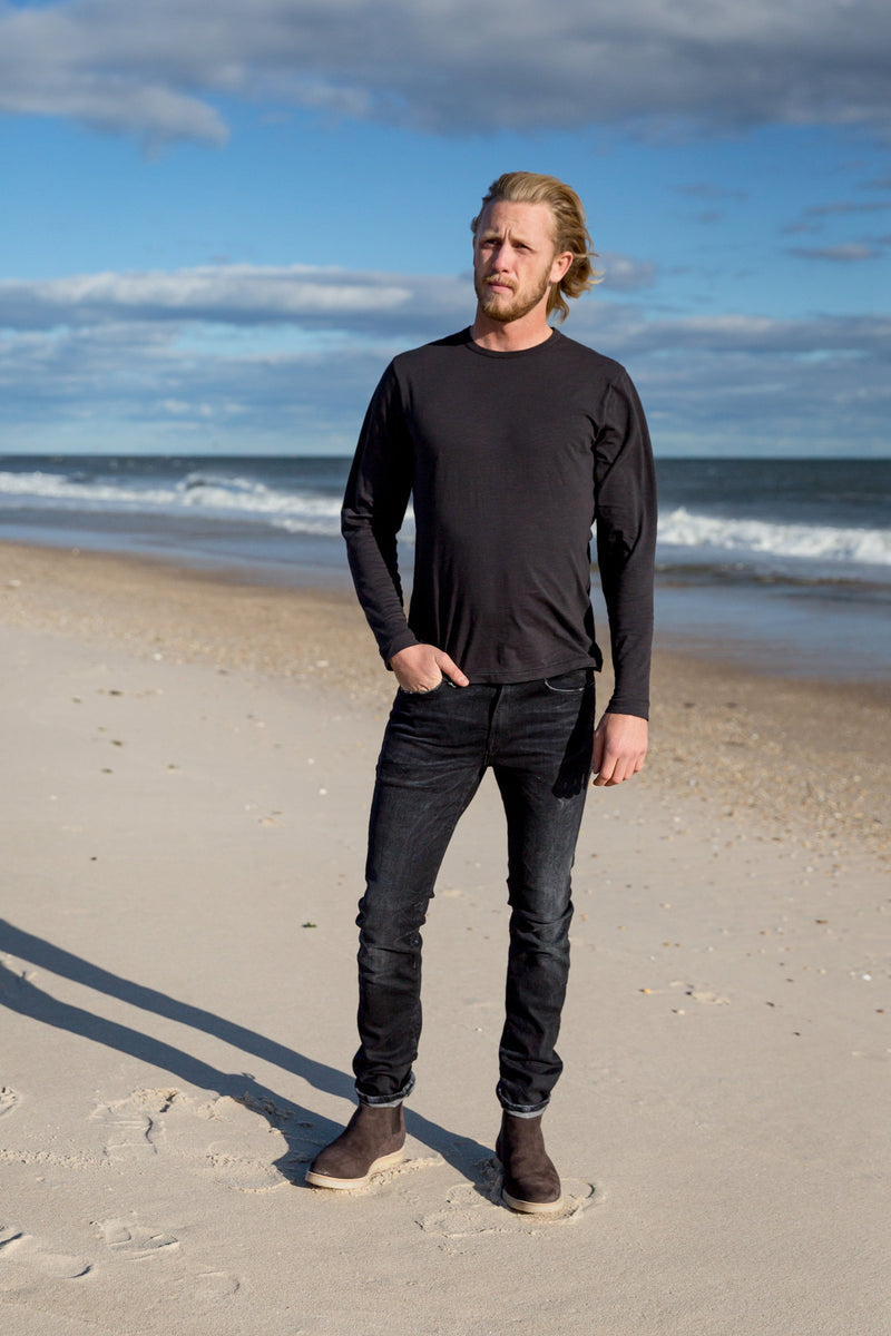 Man modeling a Standard Slub Long Sleeve Tee in black on beach